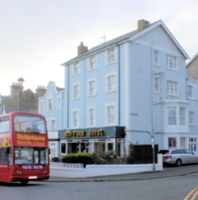 Exterior of Min Y Don Guest House in Llandudno with city sightseeing bus